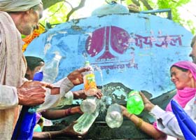 People try to fill up bottles with drinking water from a NDMC tanker. Delhiites face acute shortage of water during summers, in New Delhi on Monday