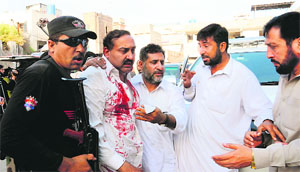 Masoom Shah Bacha (2L) of the Awami National Party, injured in a roadside explosion, arrives at a hospital in Peshawar on Sunday