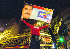 A supporters of Venezuelan President-elect Nicolas Maduro celebrates after knowing the election results in Caracas on Sunday.