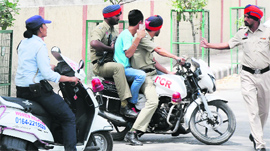Policemen catch the youth, apparently a minor, for teasing girl students and a team of the WASPS near Rajindra College in Bathinda on Tuesday.