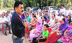 Dr Jitender Mokta addresses residents at Barmana in Bilaspur district on Monday.