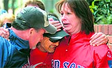 A runner being consoled by his friends after explosions in Boston