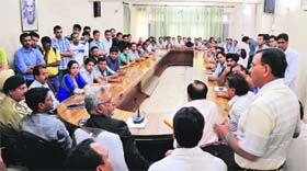 Minister for Medical Education, Taj Mohi-ud-Din, (in black coat) holds talks with junior doctors at the GMCH in Jammu on Tuesday