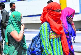 Protective gears: Women cover their faces to save themselves from dust and hot conditions in Jammu on Tuesday