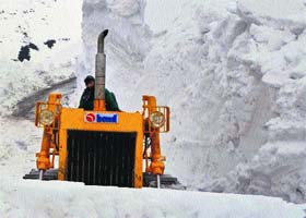 A bulldozer clears snow from the Simthan top, which connects Anantnag with Kishtwar in south Kashmir