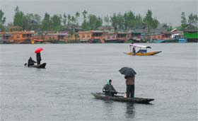 Joy ride: People cross the Dal Lake in a shikara during rain in Srinagar on Tuesday