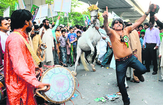 Supporters of former Pakistan's Premier Nawaz Sharif dance as they gather outside their party office during election campaigning in Lahore on Monday.