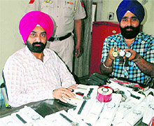 Police personnel show duplicate wrist watches in Amritsar on Wednesday