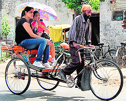 Commuters use an umbrella to protect themselves from sun on a hot summer afternoon in Amritsar on Wednesday