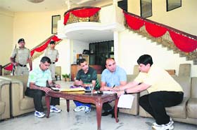 Income tax officials give a copy of the attachment order to the caretaker (right) of Sohi Banquet at Zirakpur on Wednesday