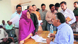 Transport and Food and Civil Supplies Minister GS Bali hears grievances of people at Pathiar village in Nagrota Bagwan on Wednesday.