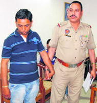 The suspect in the case of siphoning off Rs 98.77 lakh land compensation being taken away by the police from the SDM office in Jalandhar on Wednesday. 