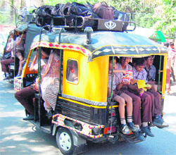 An overloaded autorickshaw takes children home in Amritsar.