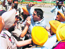 Police personnel stop members of the Unemployed Linesmen Union as they march towards the residence of State Cabinet Minister Bikram Singh Majithia in Amritsar on Thursday.