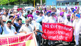 Members of the UT Employees Sangharsh Committee protest outside the ISBT-17 in Chandigarh on Thursday.