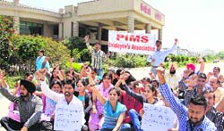 Holding banners and placards, paramedical staff of PIMS hold a protest against the management for not paying their salaries for over five months in Jalandhar on Thursday. Photo: Sarabjit Singh