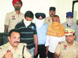 Naresh Dogra, ADCP-I, with the three accused in the land acquisition scam in Jalandhar on Thursday. Tribune photo: Malkiat Singh