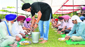 A student serves food at Gurdwara Sri Singh Sabha, PAU, in Ludhiana on Thursday. 