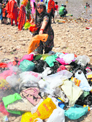 volunteers remove polythene bags and plastic material from the river in Jammu on Friday.