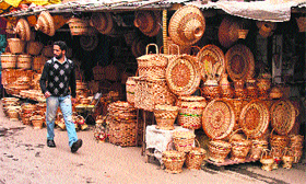 A man walks in front of a shop selling hand-made wicker products in Srinagar on Friday.