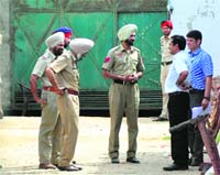 Police and custom officials outside the godown where sandalwood is kept. A Tribune photo