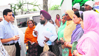 Deputy Commissioner Rajat Aggarwal (left) interacts with women at Maqboolpura in Amritsar on Saturday. 