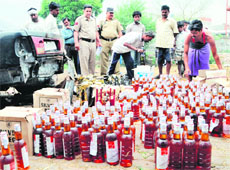 Police and excise officials with the liquor that was seized from a car at the Majitha road in Amritsar on Sunday. 