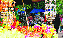 A vendor sells artificial flowers by a road in Srinagar on Sunday