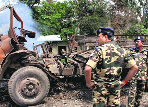 A security personnel inspects the blast site at Awang Sekmai in Manipur on Sunday. 