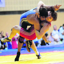 Indias Hitender grapples with Kazakstans Damitriy Popov (red) in the mens 120kg freestyle match for bronze in New Delhi on Sunday. Hitender won the bronze.
