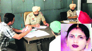 A police official writes a complaint of family members of Gurpreet Kaur (inset), who committed suicide, in Amritsar on Monday. 