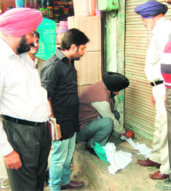 A team of the MC seals a liquor vend on the Sultanwind road for not paying the house tax in Amritsar. 