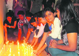 Students of the Emax Group of Institutions, Ambala, light candles in Ambala on Monday. 