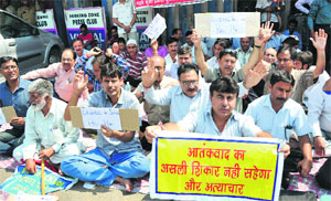 Members of the Kashmiri Migrant Relief Holders and Over Aged Youth stage protest near the Press Club in Jammu on Monday.