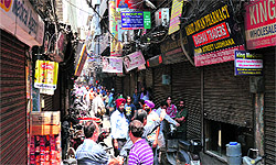 Wholesale chemists gather in front of their closed shops at the Pindi street in Ludhiana on Monday