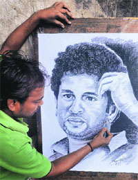 A Kolkata artist gives final touches to a sketch of Sachin Tendulkar on Monday, ahead of his 40th birthday.