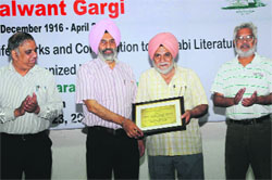 Vice-Chancellor of the Central University of Punjab, Prof Jai Rup Singh (second from left), presents a memento to renowned Punjabi author Ajmer Singh Aulakh in Bathinda on Tuesday. 