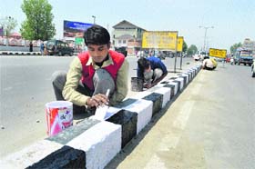 Gearing up: Ahead of darbar move, workers paint a footpath in front of the civil secretariat road in Srinagar on Tuesday