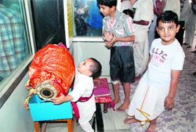 A young devotee tries to play a mridangam at the Goriya Math temple during the ceremony