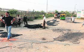 Municipal Corporation staff repair the road near the BSNL Exchange at Bhai Randhir Singh Nagar in Ludhiana on Wednesday