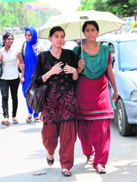Girls protect themselves from the hot sun using an umbrella on Thursday afternoon in Bathinda.