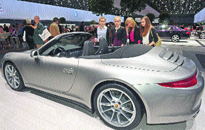 Four young girls look at a Porsche car during the annual shareholders meeting of German carmaker Volkswagen in Hanover on Thursday. Volkswagen reported a 26 per cent drop in first-quarter operating profit to 2.34 billion euros, though it stood by goals to match last year's record earnings of 11.5 billion euros and to push sales and deliveries to new records.