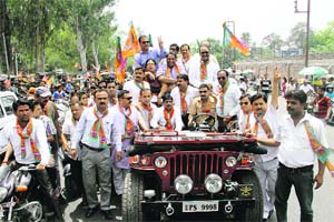 BJP mayoral candidate Vinod Chamoli take part in a roadshow organised by the party in Dehradun on Thursday. 