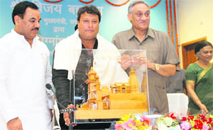 Famous film director Tigmanshu Dhulia (centre) being honoured by Chief Minister Vijay Bahuguna at a function in Dehradun on Thursday.