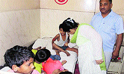 A doctor examines children in the General Hospital, Fatehabad, on Thursday