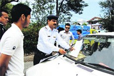 A policeman issues a challan for wrong parking on the Kangra road in Dharamsala on Thursday.