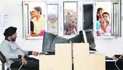 Applicants make a beeline at token counter of Suwidha Centre which remained closed due to power failure in Jalandhar on Thursday. 