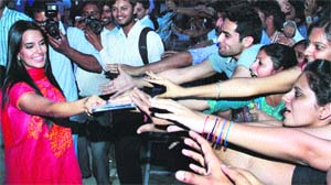 Bollywood actor Neha Dhupia shakes hands with students near Jalandhar on Thursday.