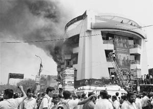 People gather as fire personnel carry out rescue work after a major fire broke out in a commercial complex in Coimbatore on Thursday.