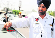 A traffic policeman removes a police sticker from a car in Amritsar. 